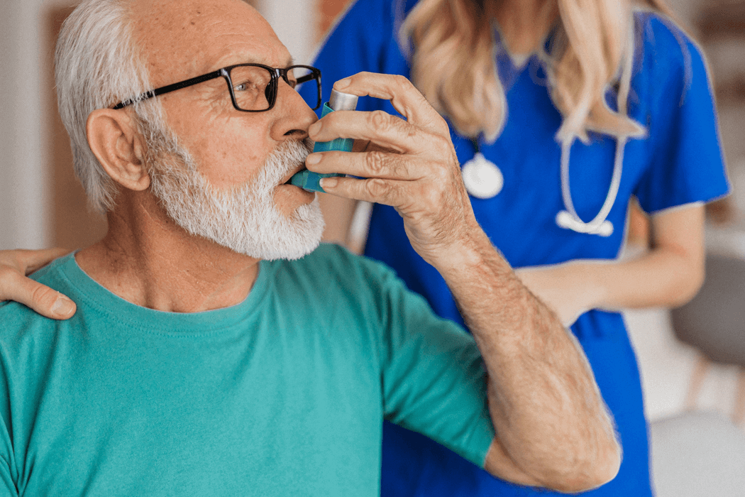 Doctor assisting patient with using an inhaler