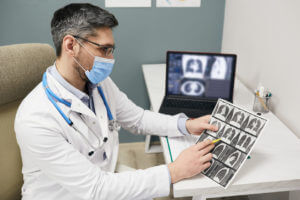 pulmonologist checking results of patient's lungs CT scan at a medical clinic