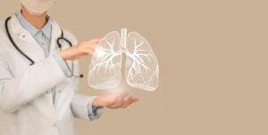 A pulmonologist is holding a highlighted, hand-drawn illustration of lungs in their hands while explaining lung cancer.