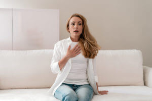 Woman has chest pain and trouble breathing at home during a asthma attack.